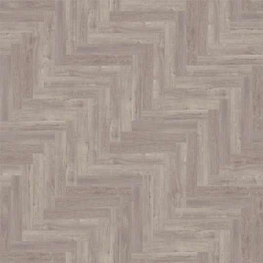 Close-up of County Oak LVT herringbone pattern, highlighting the rich wood effect and texture.