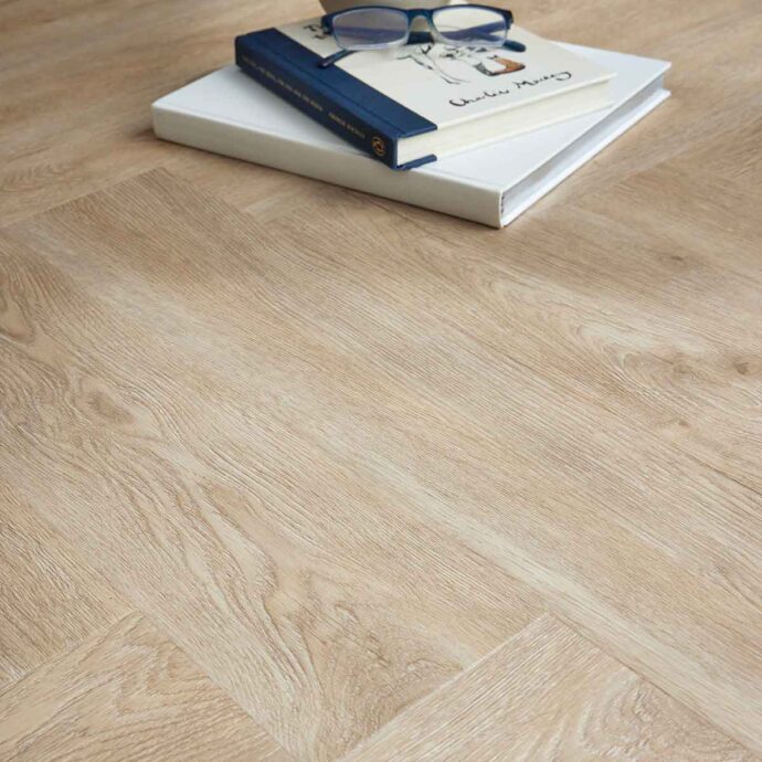 Glue-down herringbone luxury vinyl tile flooring in warm light and medium oak tones, designed for high-traffic areas.