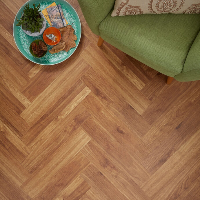 Close-up of Golden Oak Parquet LVT planks by AClass Flooring – Durable, water-resistant herringbone LVT with a micro bevel edge and a natural golden oak look.