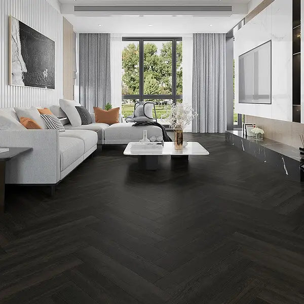 Antigua Charcoal Oak herringbone LVT in a contemporary living room with dark wood tones.
