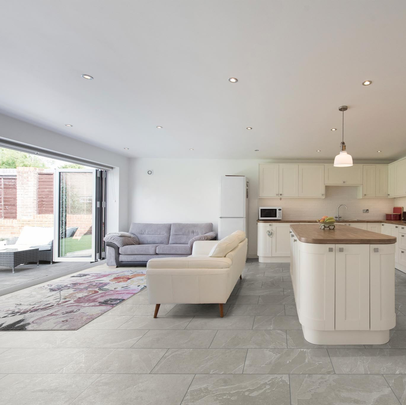 RHINOFloor Evolution LVT in Oxford Pebble Grey, featuring light grey stone effect flooring with a polished bevelled edge in a contemporary kitchen setting.